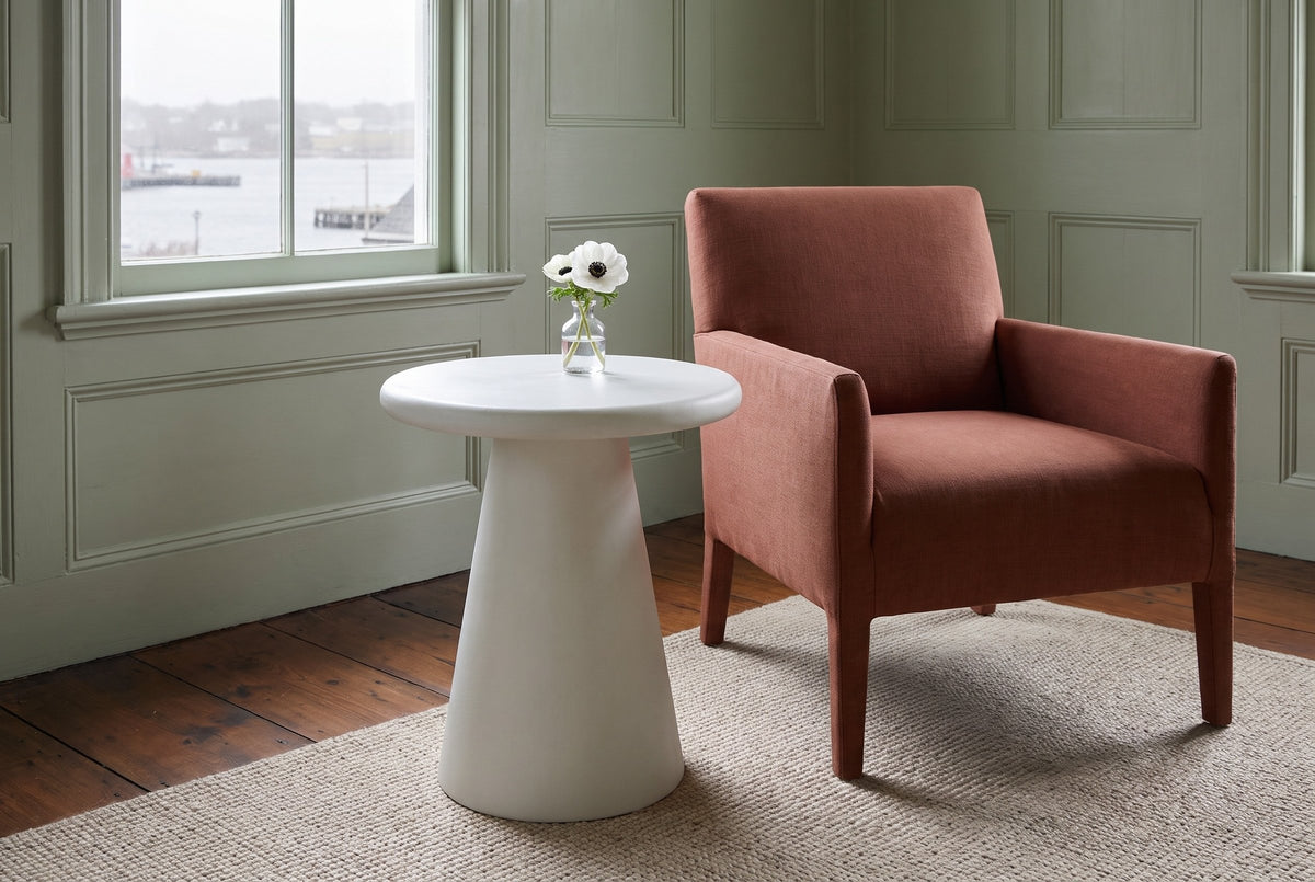 Levico round white side table beside a rust linen armchair in a sage-panelled Lunenburg sitting room, the harbour through the window