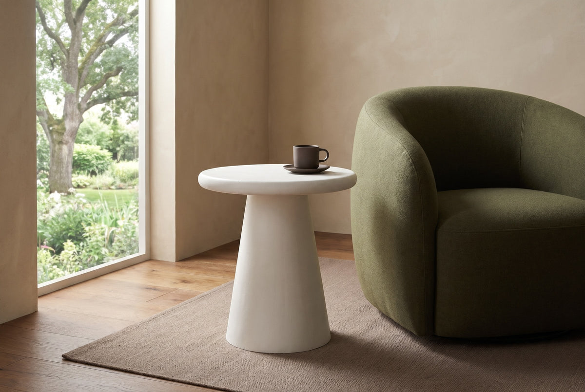 Levico round white side table beside an olive wool lounge chair in a sand plaster Victoria living room, a brown cup on the top