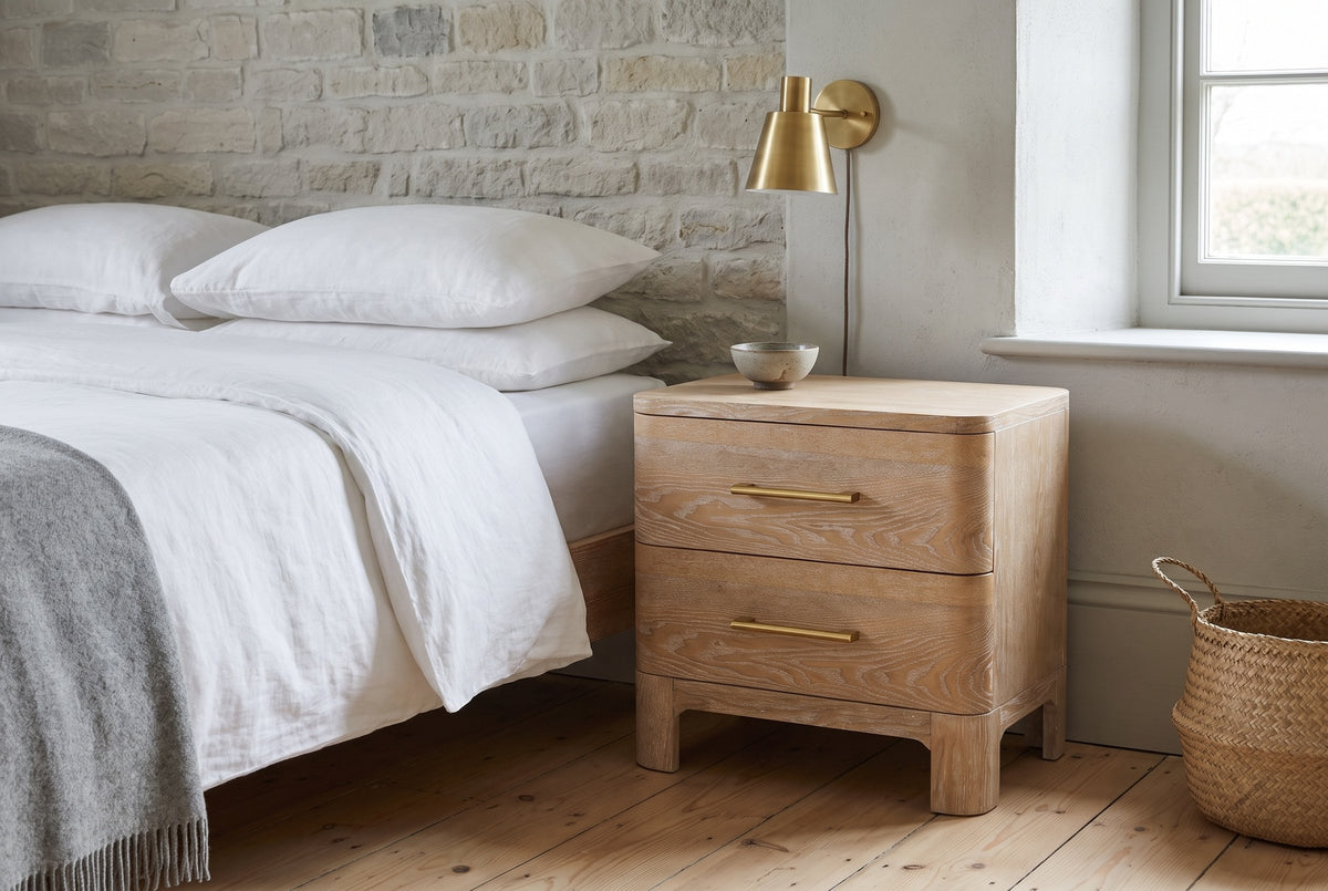 Lodi nightstand in Natural against a limestone wall in a Quebec City bedroom with white linen