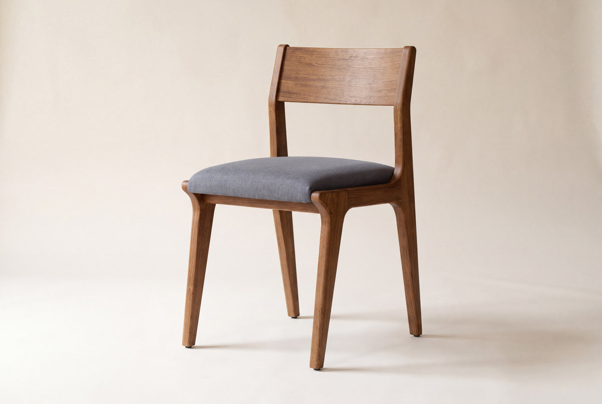 Lucrezia dining chair in the Walnut finish on a studio backdrop, front three-quarter view