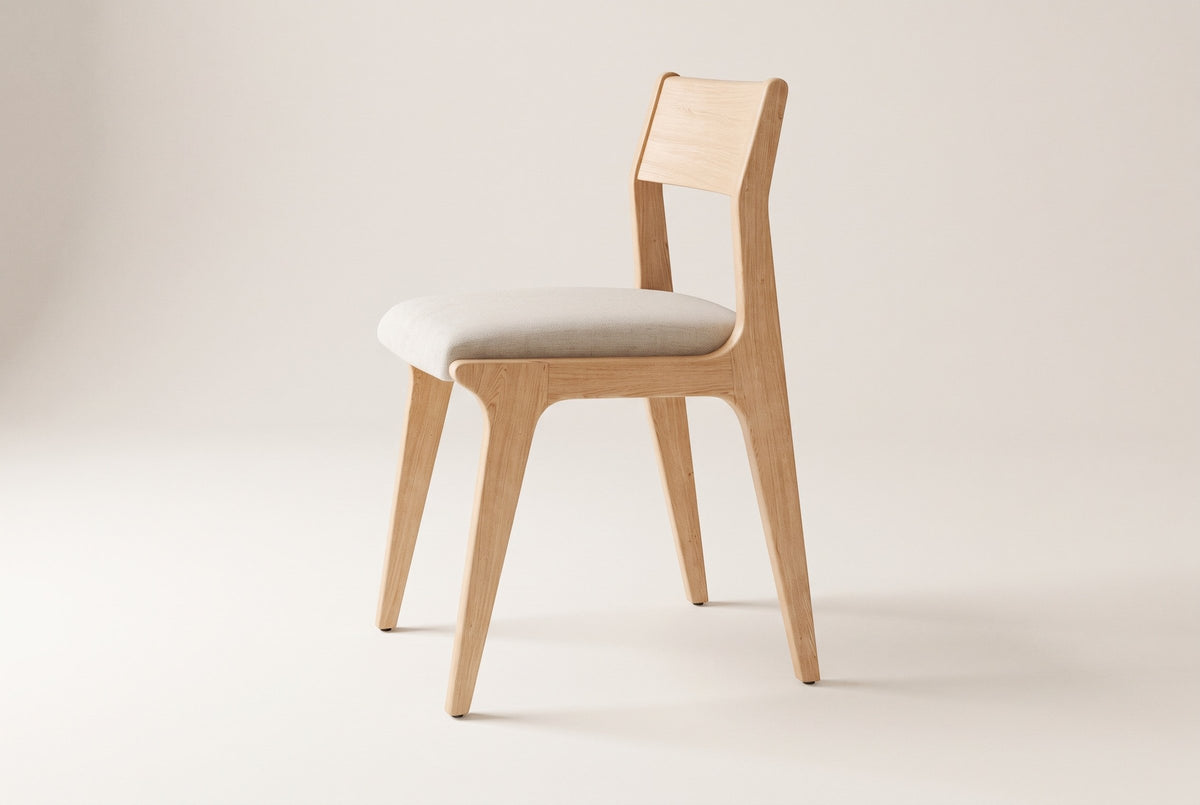 Lucrezia dining chair in the White Oak finish with an off-white fabric seat, side three-quarter view on an off-white background
