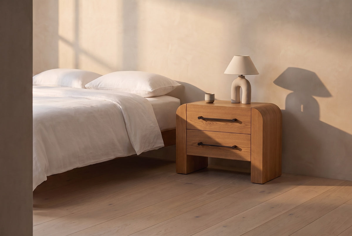 Macerata nightstand in brown beside a bed in white linen, in a plaster-walled bedroom in late golden light