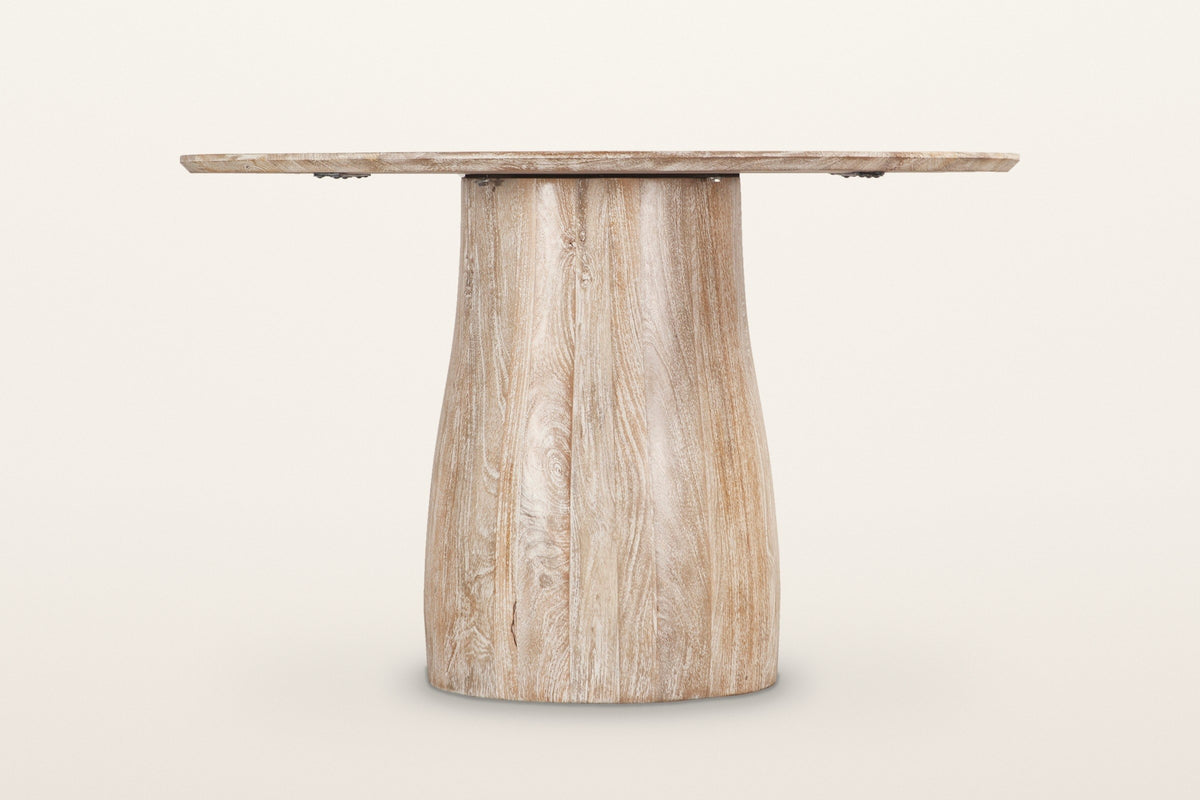 Marano dining table in Natural White Wash, level side view on a warm white studio backdrop: the pedestal narrow under the top