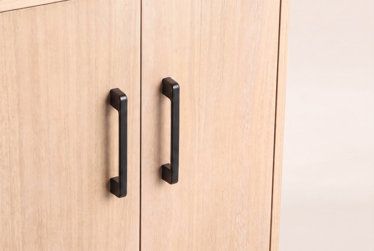 Close-up of two Maren cabinet doors in Natural meeting in the middle, with their two slim matte black metal handles