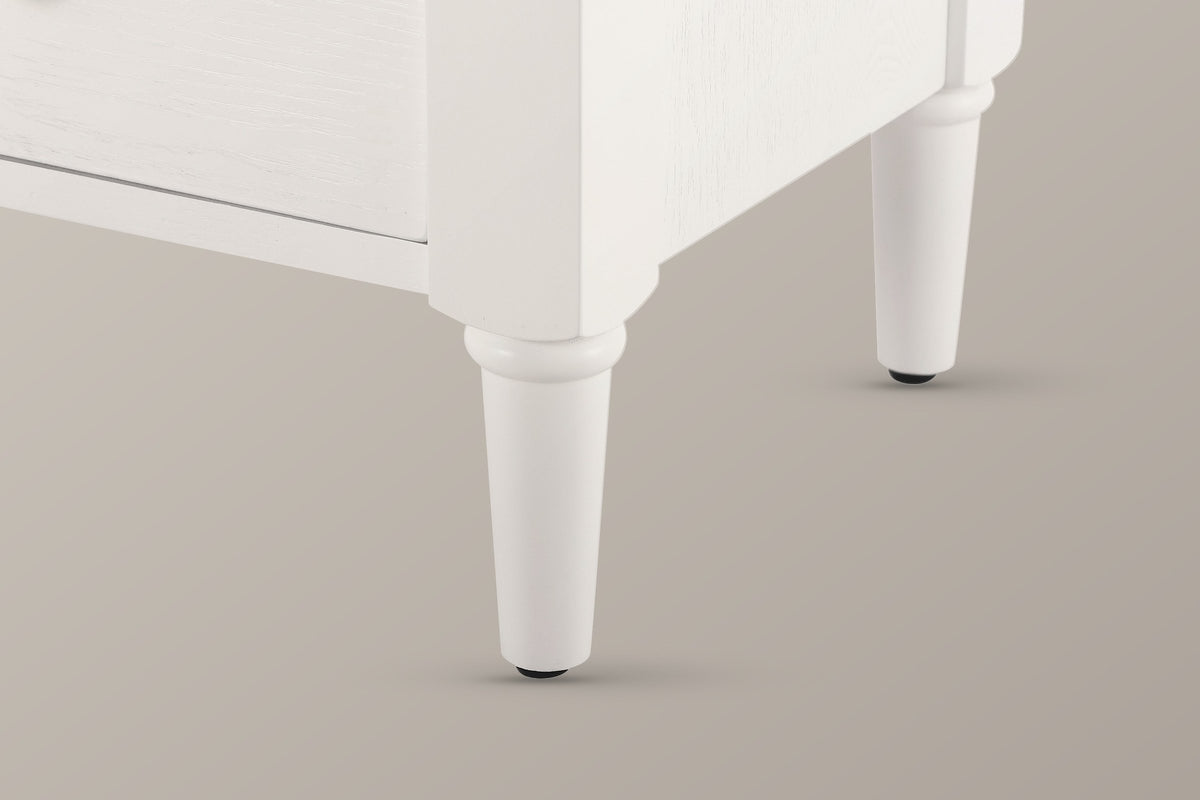Close-up of a Marsala front leg in Milk White: the white chamfered corner stile and the turned, tapered leg