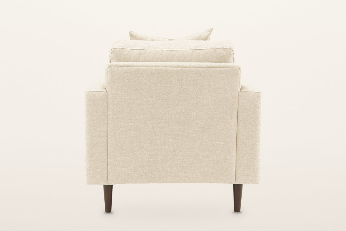 Mombaruzzo accent chair from behind on a warm white studio backdrop: a plain upholstered back on four tapered legs
