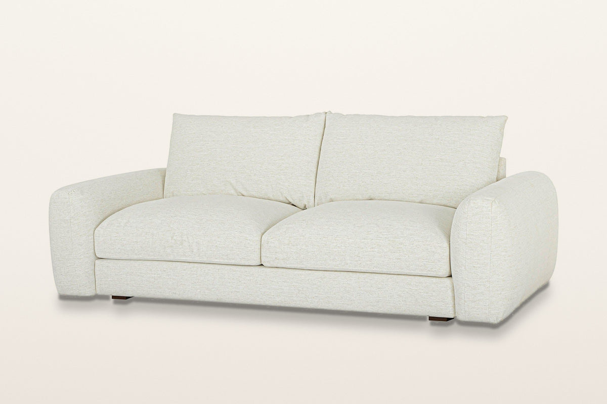 Montecassiano rounded arm sofa in Cream, three-quarter view on a warm white studio backdrop: thick domed arms