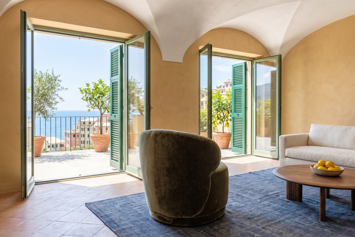 Monterubbiano accent chair in Khaki Green velvet seen from behind in a Camogli villa in Liguria, ochre limewash