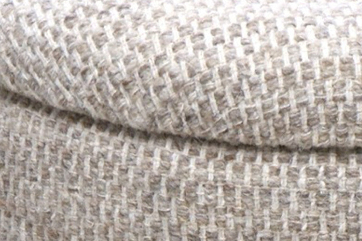 Close-up of the Morgex pouf: the padded lid's rounded edge over the drum, with a fine shadow line between them