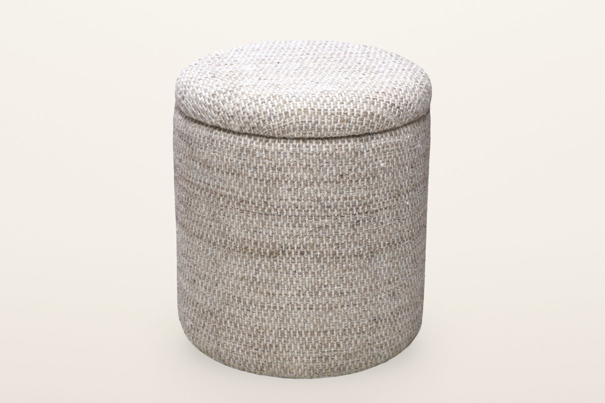 Morgex round storage pouf in Beige on a warm white studio backdrop: a drum of basket-weave wool with a padded round lid
