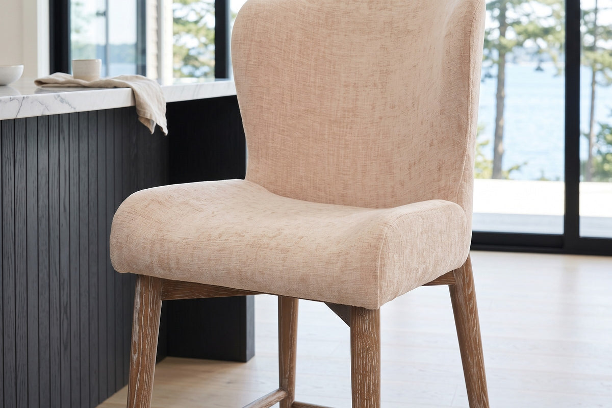 Close-up of the Morrovalle seat and back in Champagne Chenille: the back curves forward at the shoulders and the seat edges r