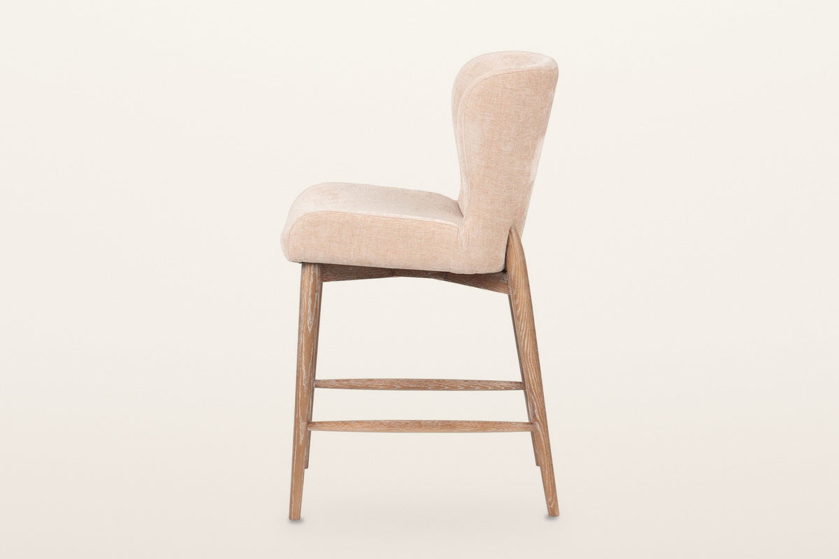 Morrovalle counter stool in Champagne Chenille, side view on a warm white studio backdrop: the curved back