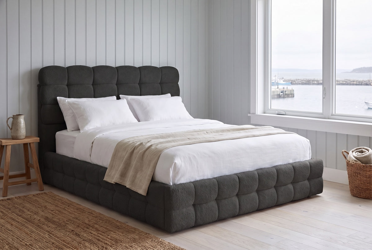 Nemi bed in black bouclé in a pale plank-walled Halifax bedroom with a window onto the harbour