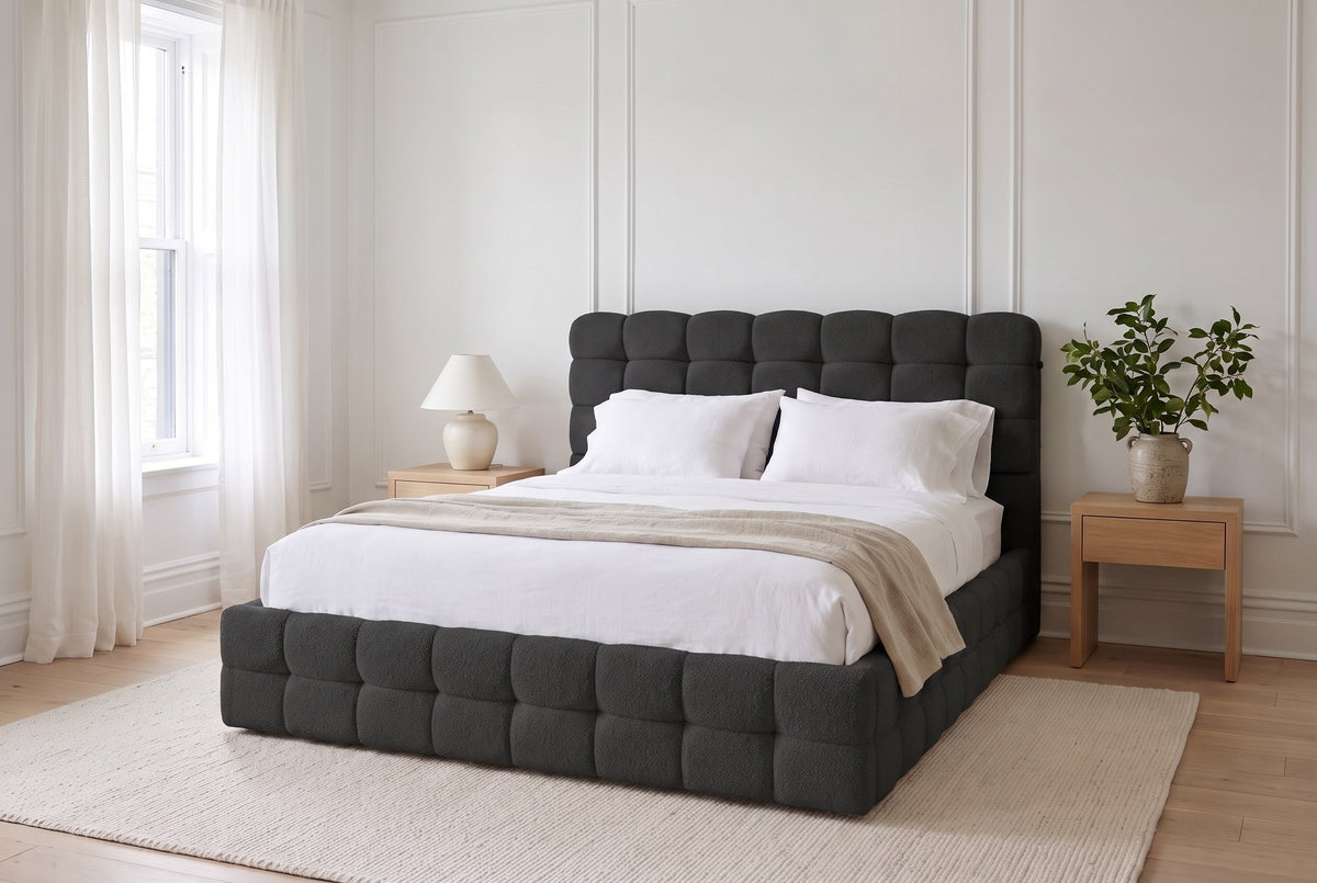 Nemi bed in black bouclé made up with white linen in a bright Montreal bedroom with wall mouldings