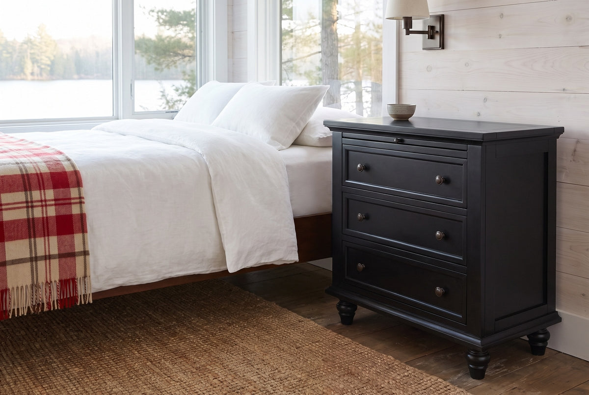 Nervi nightstand in Black beside a bed with white linen in a whitewashed Muskoka cottage bedroom by the lake