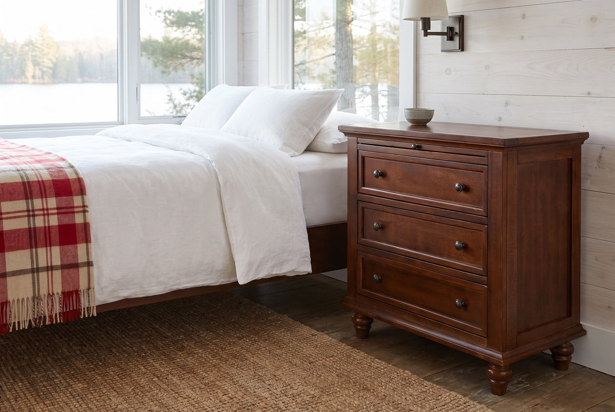 Nervi nightstand in Brown beside a bed with white linen in a whitewashed Muskoka cottage bedroom by the lake