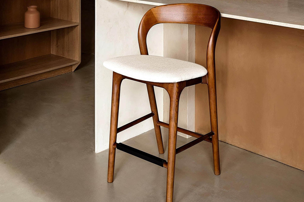 Norwood walnut and cream counter stool at a pale stone kitchen island