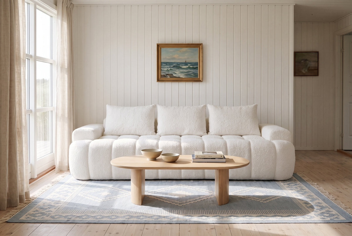 The Nuvola sofa in White in a Skagen summer house with white board walls, a pine floor and a blue and white rug