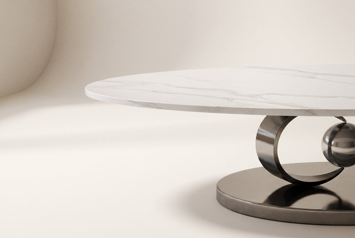 Close-up of the Oriana coffee table's white sintered stone top with soft grey veining, its slim straight edge and the gunmetal ring below