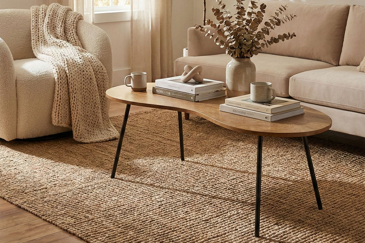 Ottilie mango wood coffee table with books and a vase in a sunny living room with a cream sofa