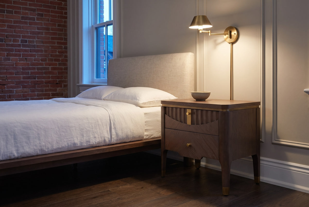 Pavia nightstand in Brown beside a bed in a panelled Ottawa townhouse bedroom at dusk, a brass swing-arm lamp lit above it
