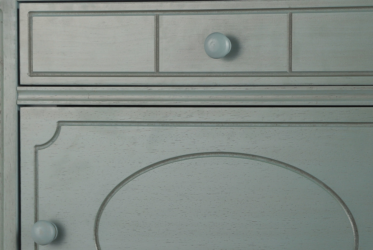Close-up of the Perugia nightstand in Aged Blue: the drawer front with three routed panels and a round knob painted to match