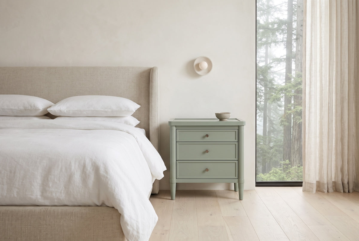 Pescara nightstand in Sage Green beside a bed with white linen in a plaster Vancouver bedroom with a misty cedar view