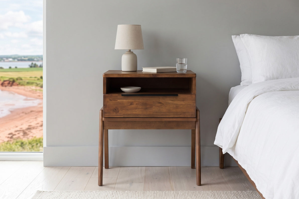 Front view of the Pescasseroli nightstand in Brown acacia beside a white linen bed in a bedroom in a Charlottetown harbour ho