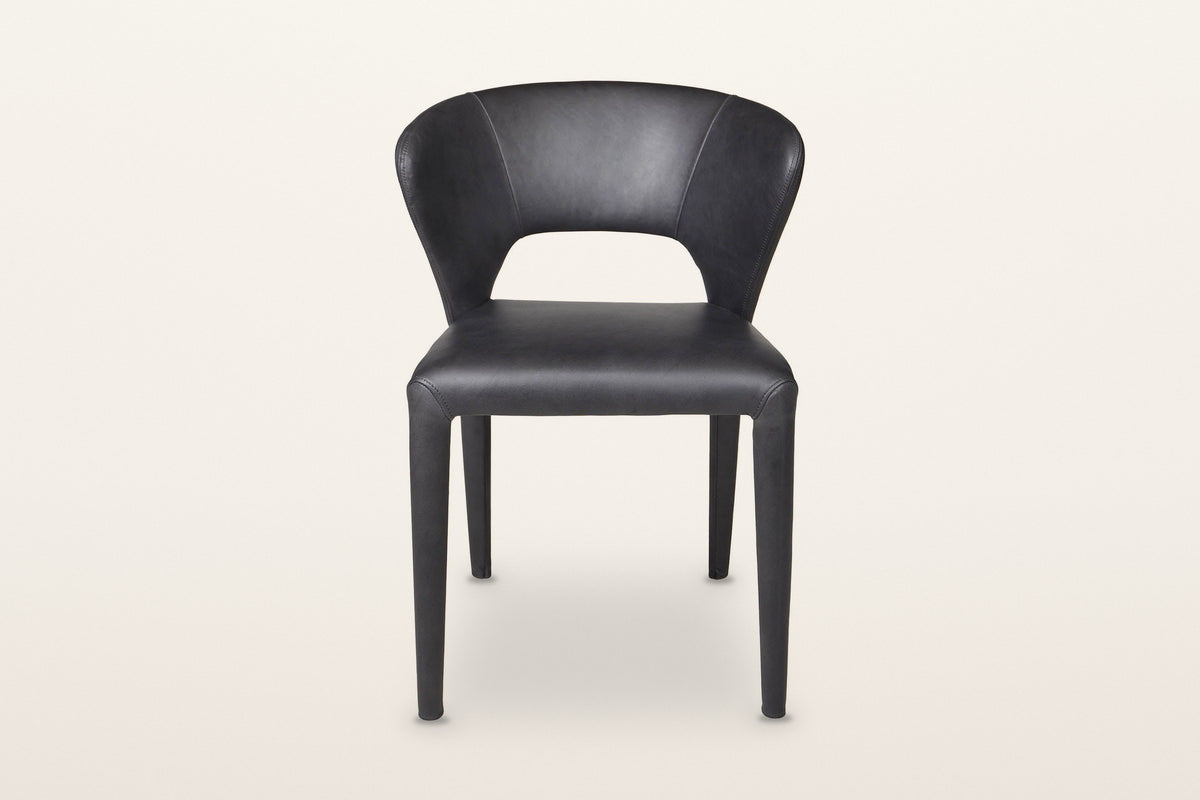 Petralia dining chair in Black leather, straight front view on a warm white studio backdrop: the open window between the seat