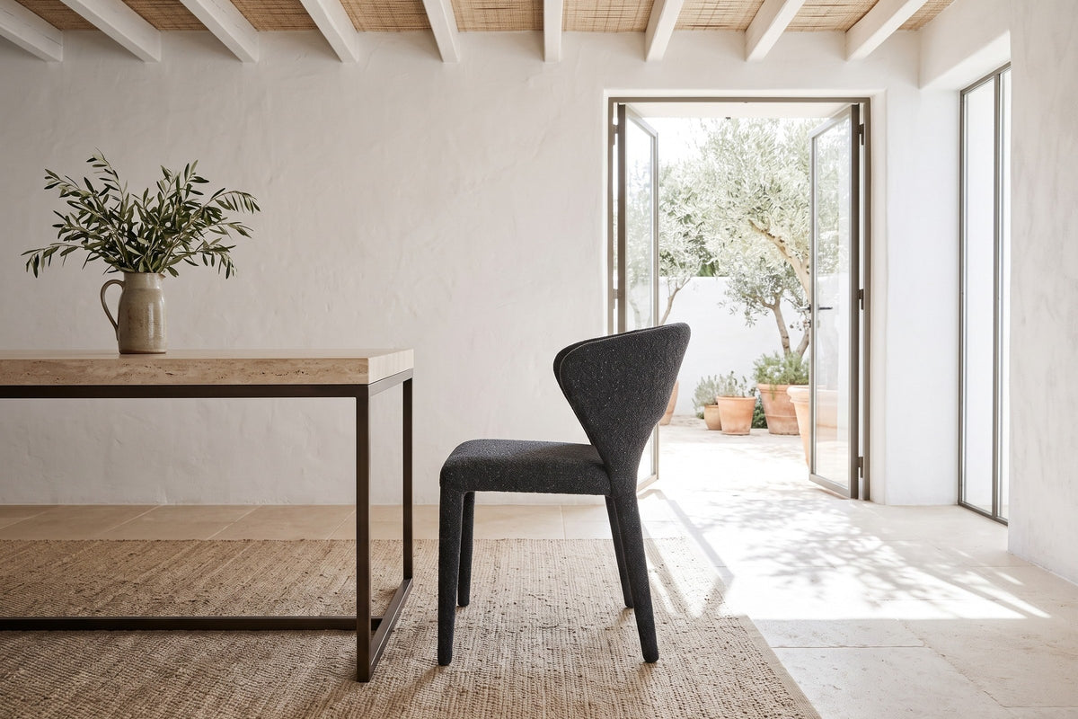 A Petralia dining chair in Dark Grey in side profile in a Menorca courtyard house