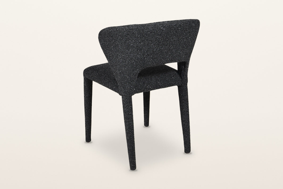 Petralia dining chair in Dark Grey from the back at three-quarter on a warm white studio backdrop