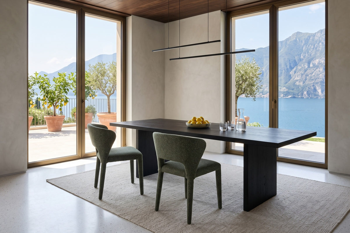 Two Petralia dining chairs in Green seen from above at an ebonised oak table in a Lake Garda villa