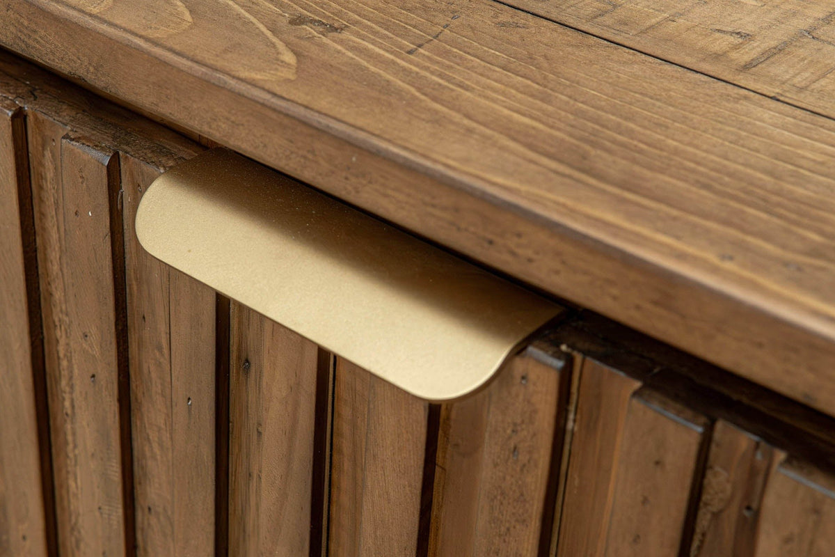 Close-up of a brass pull on the top edge of a Pettorano door in Brown, over the rounded pine slats, below the planked top