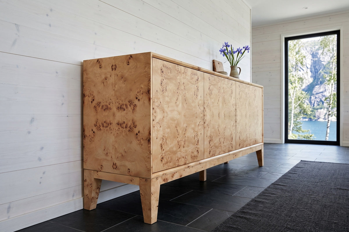 Polcenigo sideboard in Honey Blonde Burl seen from the end against whitewashed spruce boards in a house near Stavanger
