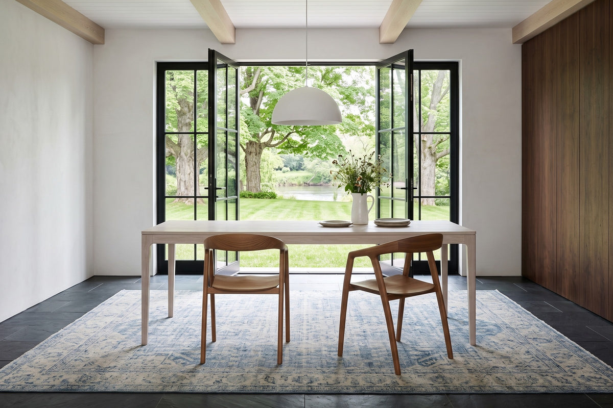 Two Pollica dining chairs in Caramel seen from behind at a whitewashed oak table in a Perth stone house