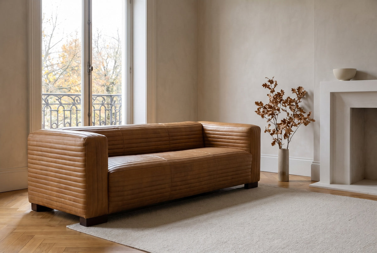 Pontremoli leather sofa in Latte in an Outremont, Montreal living room with herringbone parquet and a white fireplace