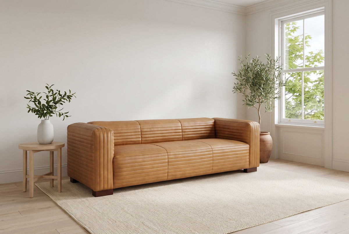Pontremoli channel-stitched leather sofa in Latte in a bright Cabbagetown, Toronto living room, an olive tree by the sash window