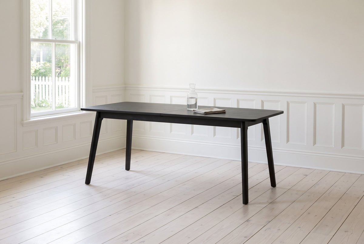 Prescott extension dining table in Antique Black with a glass carafe and a linen napkin, in a panelled Victorian dining room in Halifax, Nova Scotia