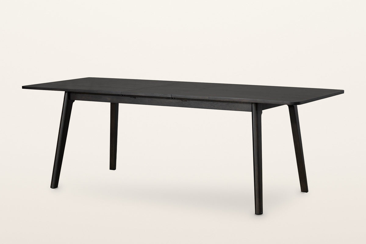 Prescott extension dining table in Antique Black opened to 86 in, the folding centre leaf in place
