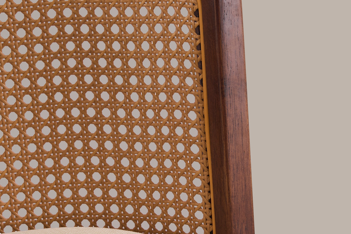 Close-up of the Rasiglia cane-look back panel with its golden edge strip, the walnut frame and the beige seat