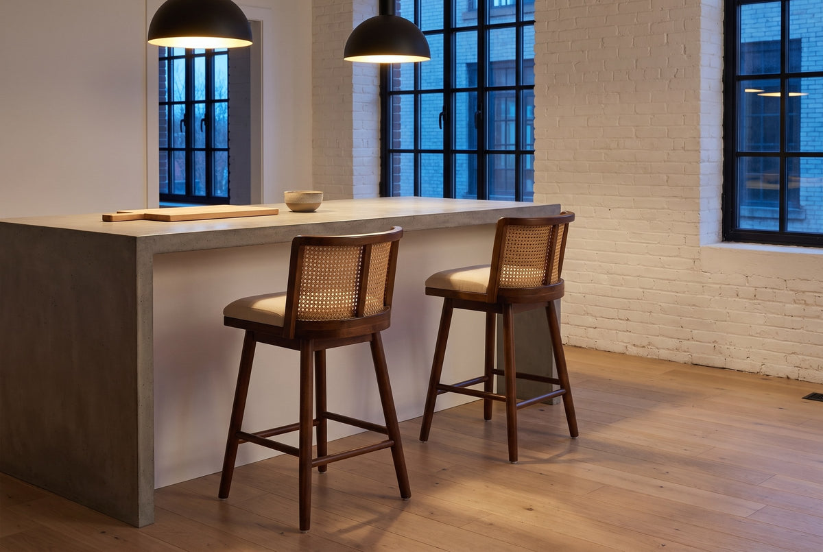 Two Rasiglia counter stools at a concrete island under black pendant lamps in a Montreal loft kitchen at dusk