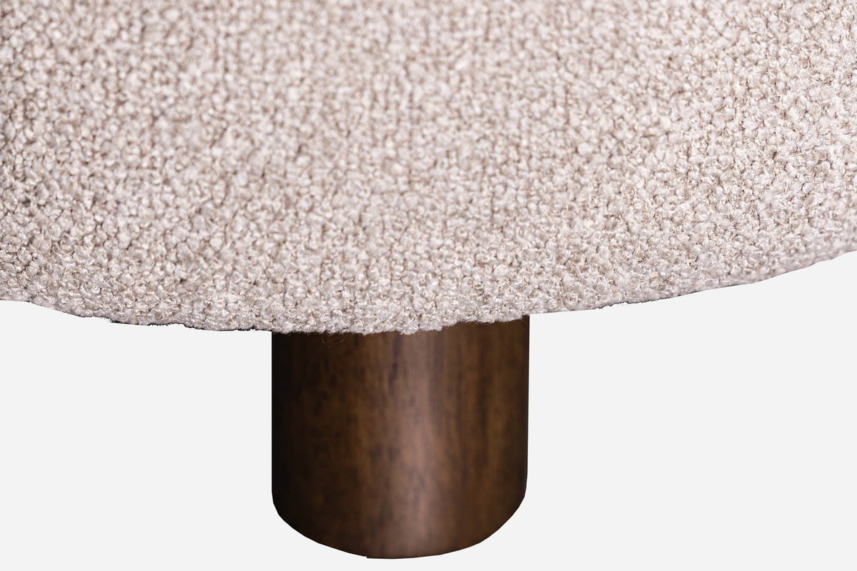 Close-up of a Ripatransone leg: a short round dark brown rubberwood leg under the textured fabric base
