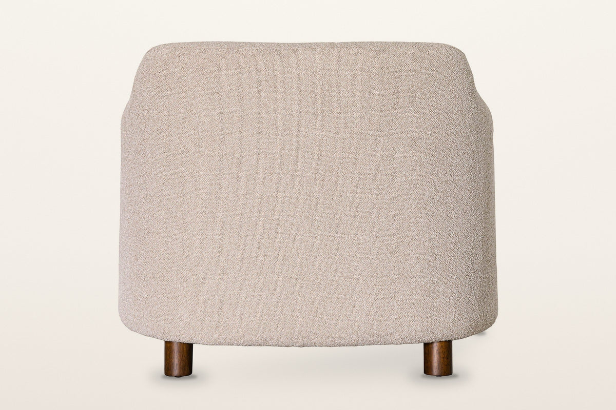 Ripatransone accent chair in Beige from behind on a warm white studio backdrop: a plain rounded back on four short round legs