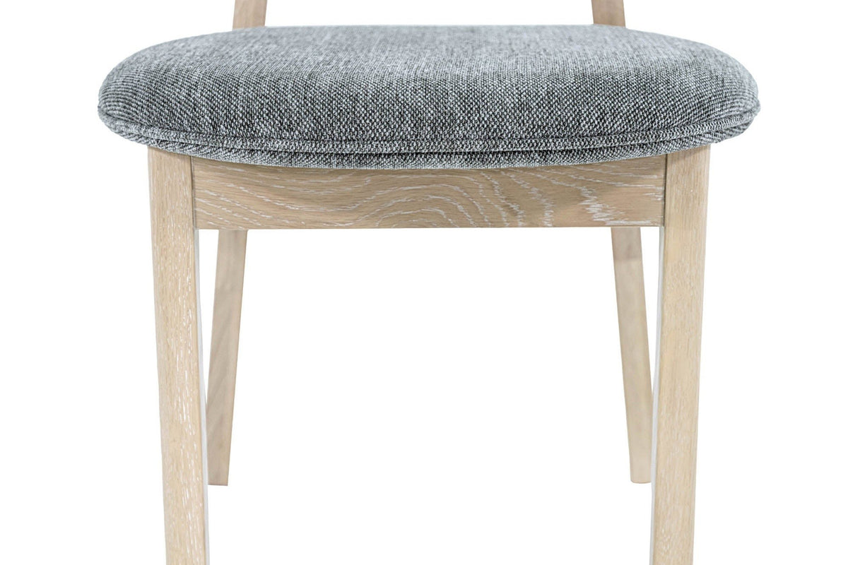 Close-up of the Rivello seat: the Toffee Mist pad with its self-piped edge on a plain oak apron and square front legs