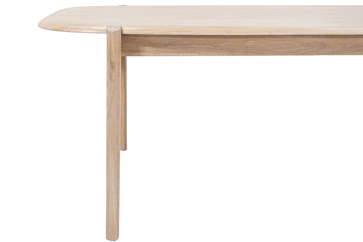 Close-up of a Rivello leg in Light Oak rising into a half-round notch in the edge of the top