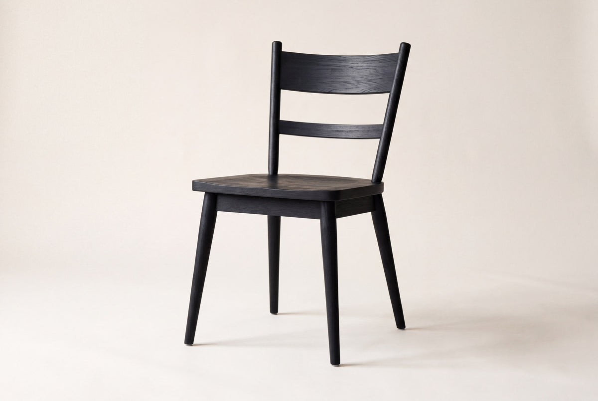 Rocco ladder-back dining chair in solid oak with a wire-brushed, ebonized black finish on a studio backdrop