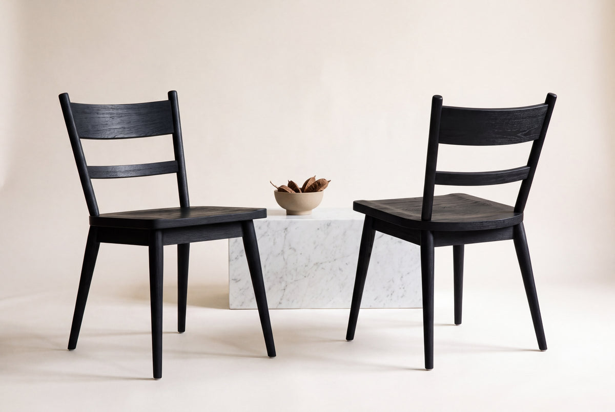 Two Rocco dining chairs in ebonized black oak, one seen from the front and one from behind