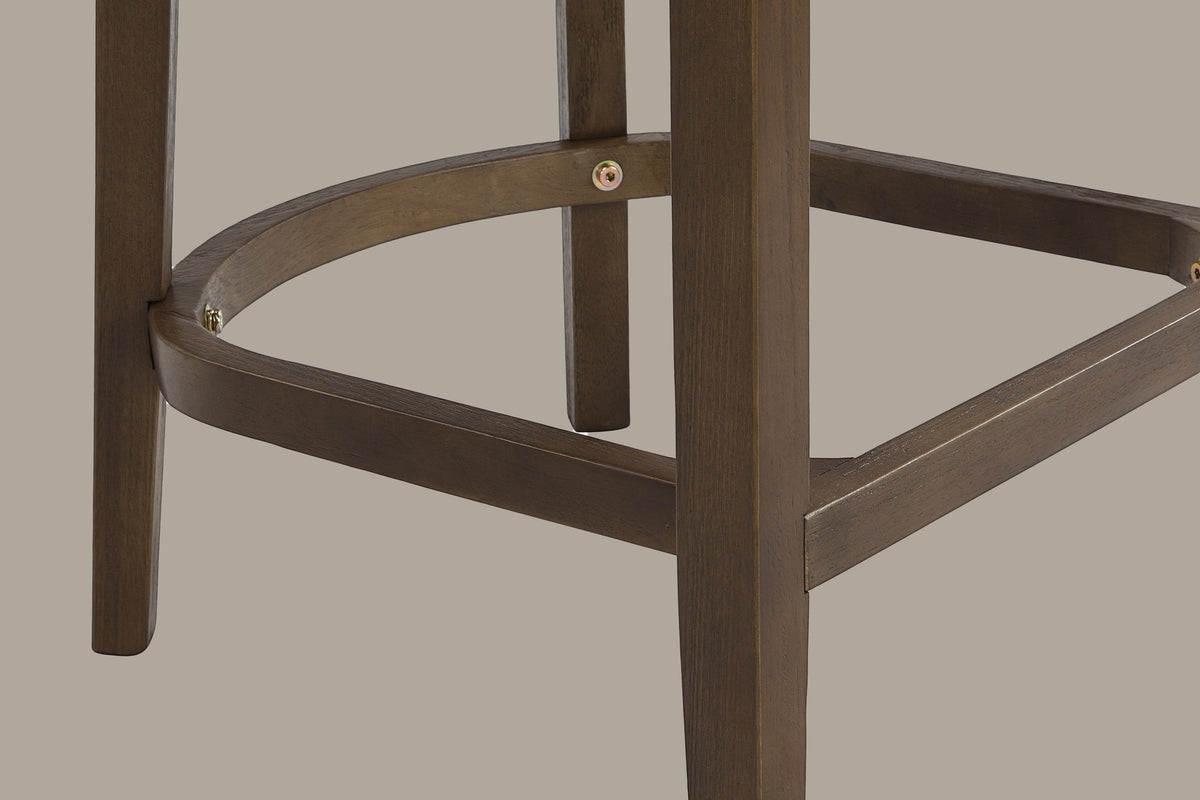 Close-up of the D-shaped wooden footrest of the Walnut Sabaudia counter stool with its exposed brass-tone hex bolts
