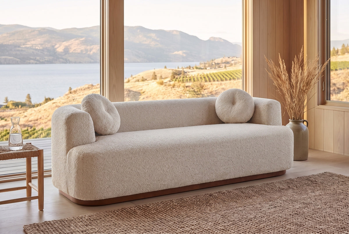 Sabbioneta sofa in Almond boucle in a Kelowna lake house with a jute rug, a rush stool and Okanagan Lake through the windows