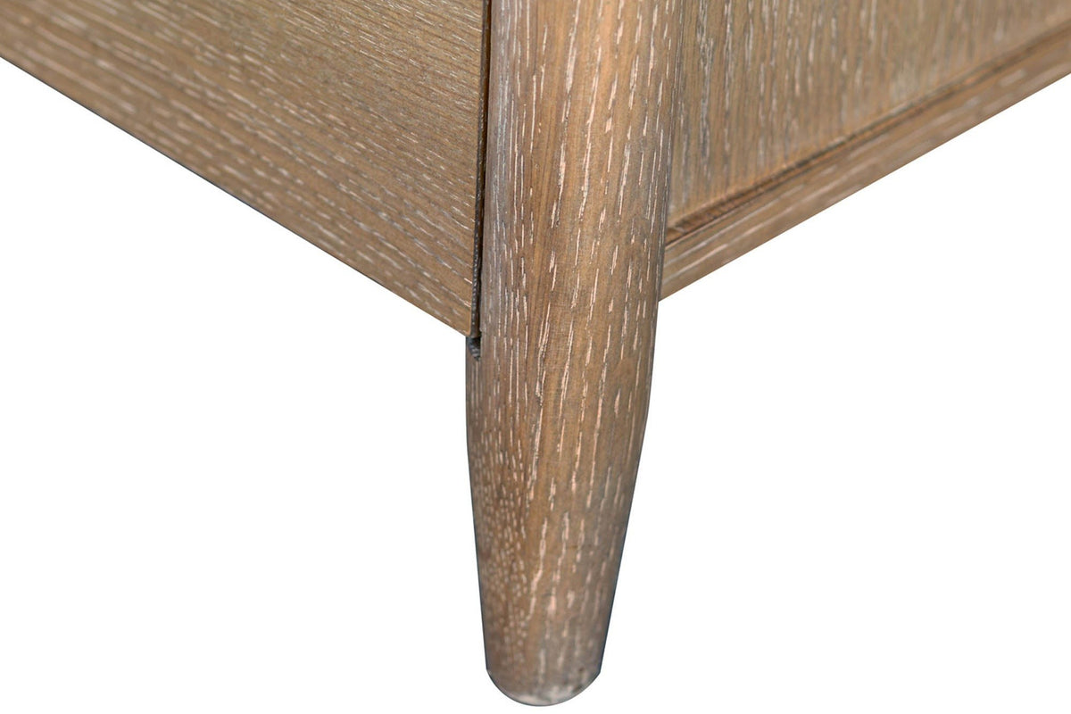 Close-up of a Sarnano corner post in Sand oak running down into a short round tapered leg